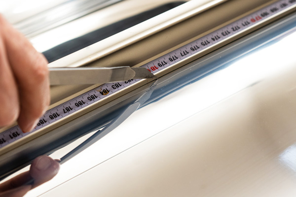 Eine Spiegelfolie wird zurechtgeschnitten